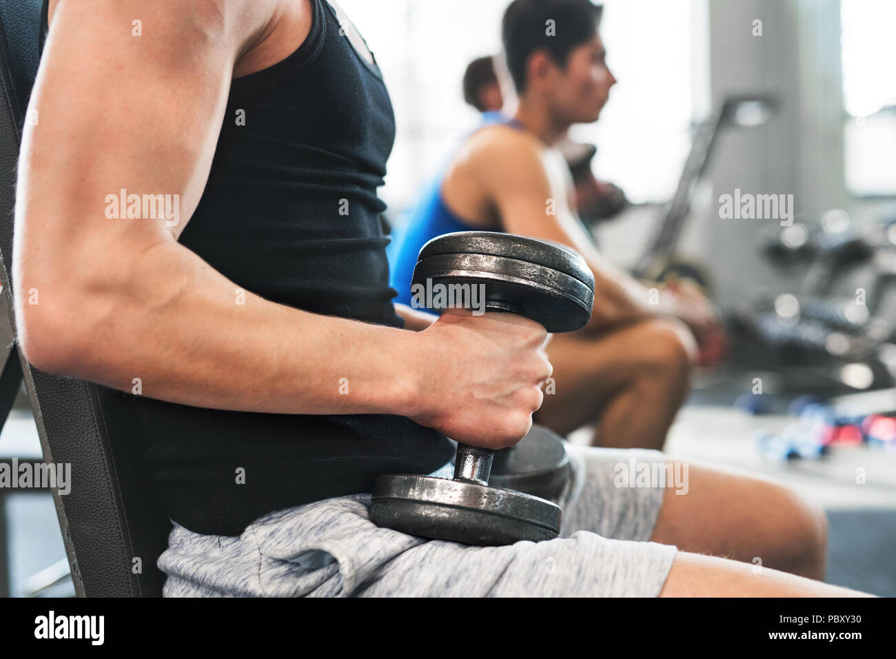 Les jeunes hommes en fit méconnaissable de sport l'entraînement avec haltères. Banque D'Images