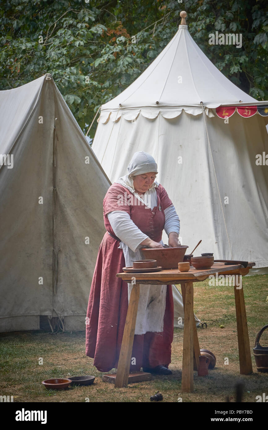 ARUNDEL, Sussex de l'Ouest/FRANCE - 28 juillet 2018 : une actrice prépare la nourriture dans le cadre d'une reconstitution de bataille médiévale au château d'Arundel Banque D'Images