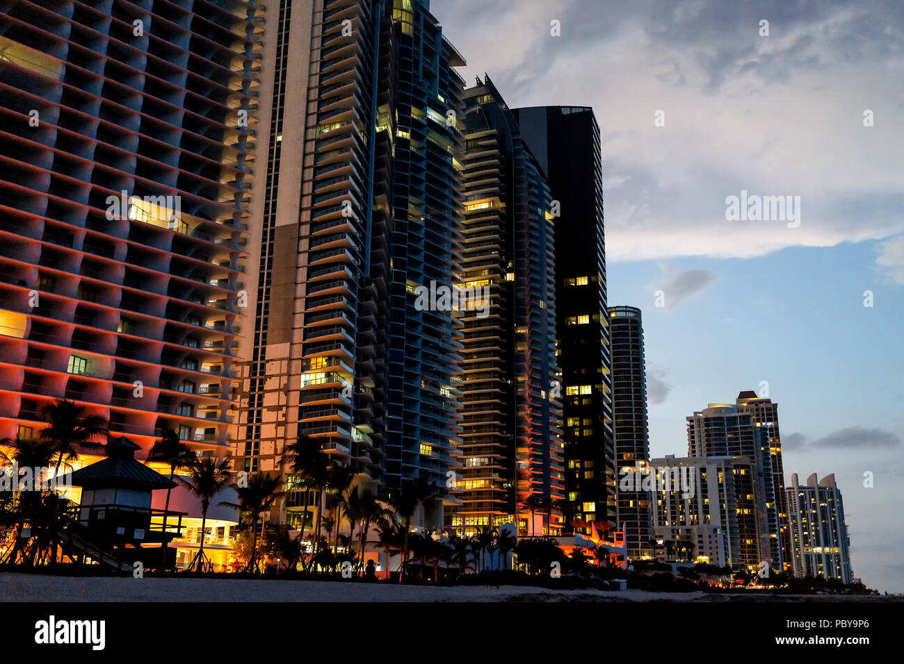 Sunny Isles Beach, appartement, condo, bâtiments de l'hôtel durant la nuit sombre soir heure bleu allumé coloré couleurs à Miami, en Floride avec des gratte-ciel Banque D'Images