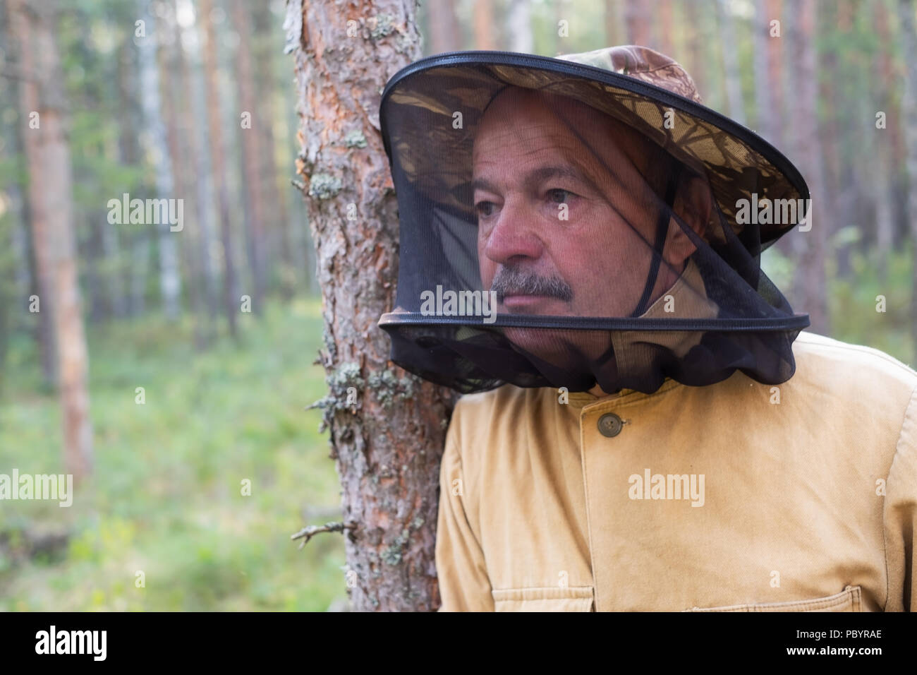 Couple mature en anti moustiques spécial cap debout dans la forêt et reste Banque D'Images