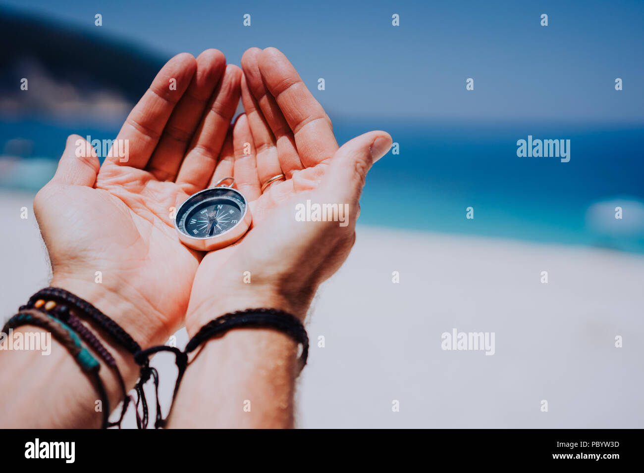 Main ouverte paume avec boussole sur la plage de sable. Vous cherchez votre chemin concept. Mer bleue en arrière-plan. Pov point de vue Banque D'Images