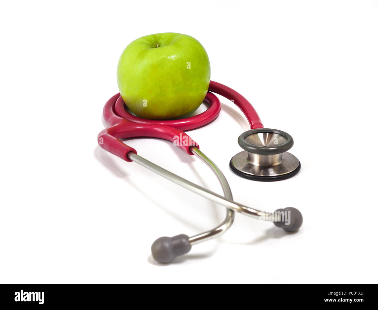 Stéthoscope et frais vert pomme sur fond blanc. Concept de vie et d'aliments sains. Banque D'Images