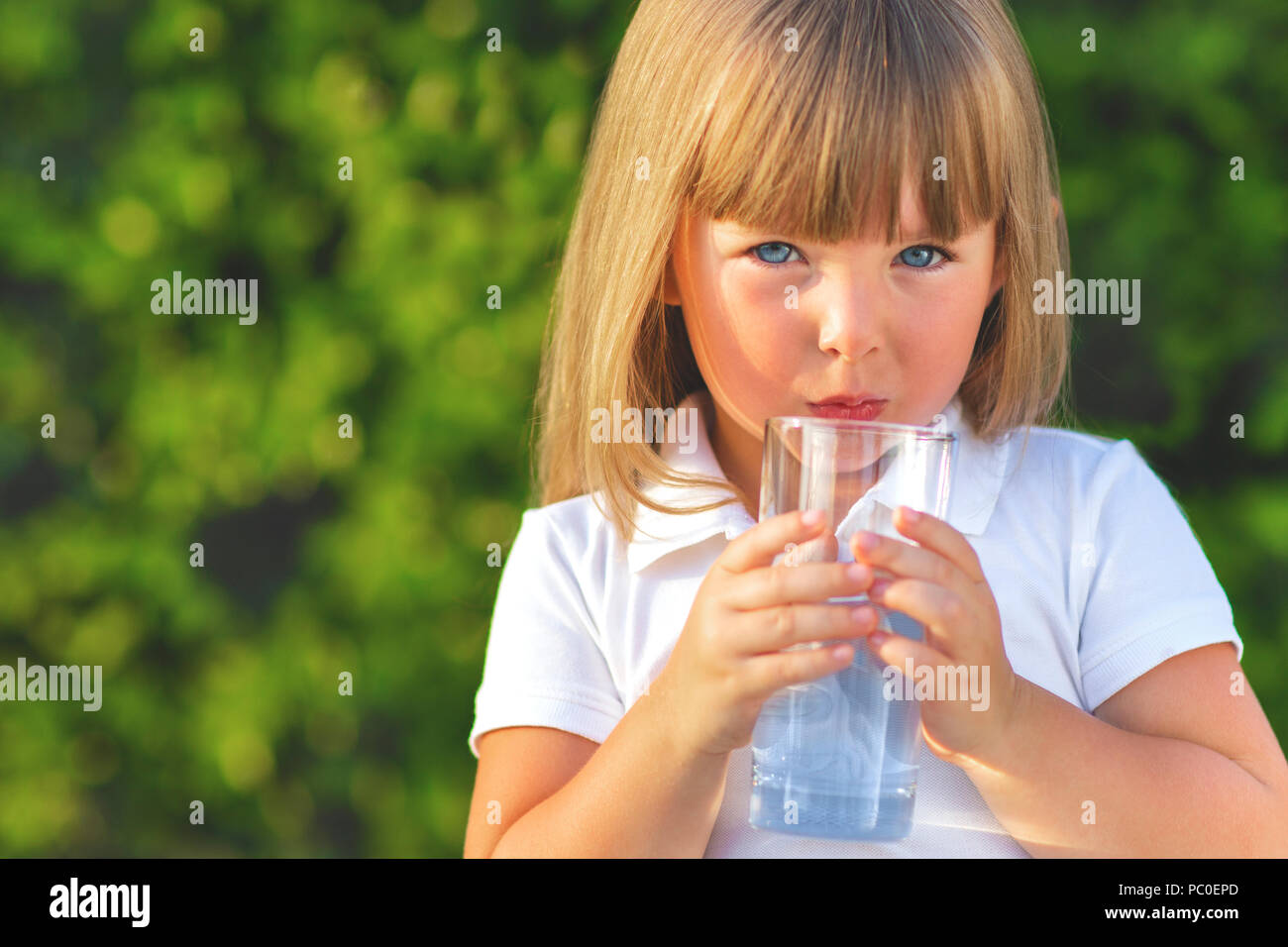 Enfant de l'eau potable. Girl outdoors Banque D'Images