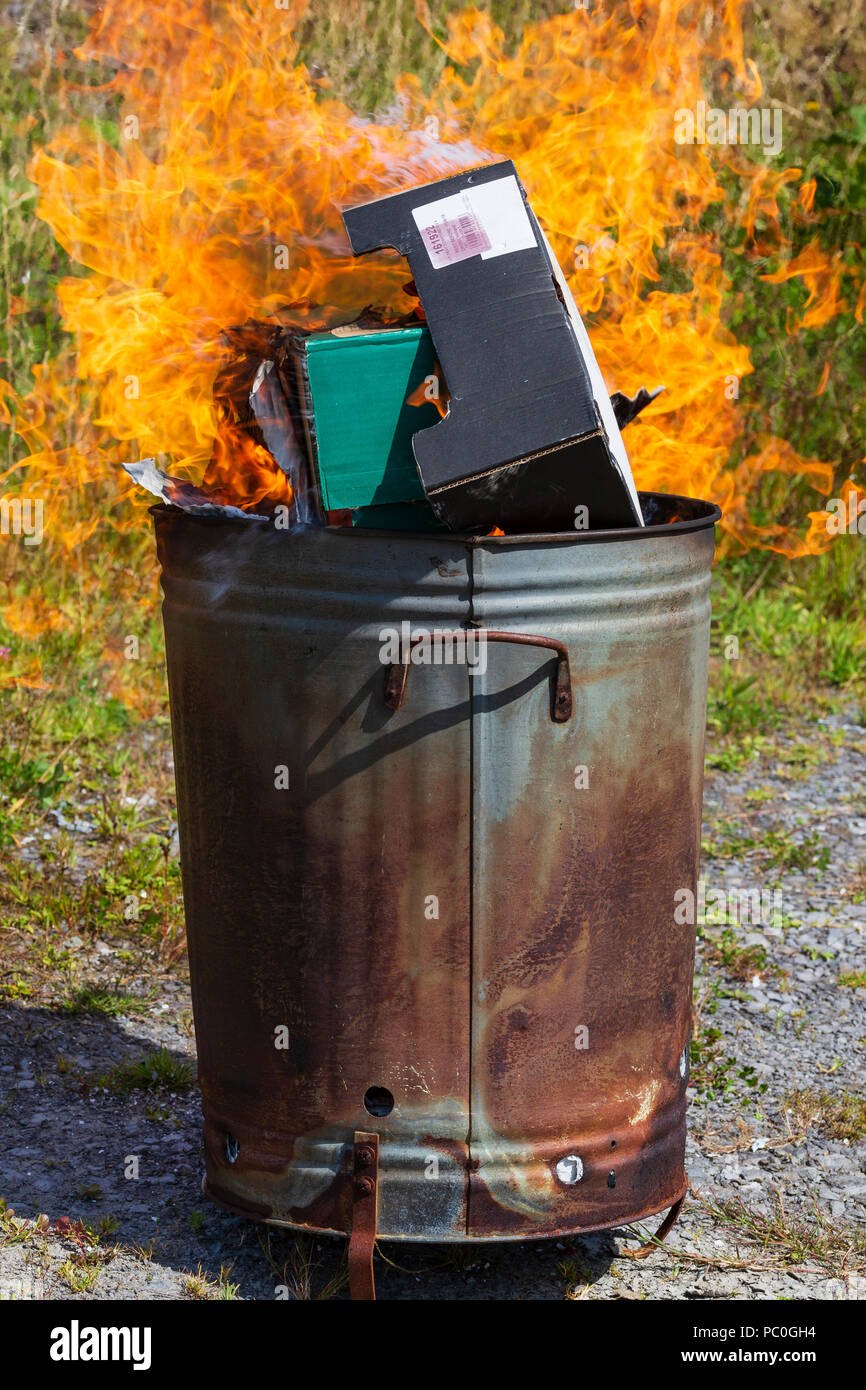 La combustion de déchets papier et carton en petit incinérateur de jardin Banque D'Images