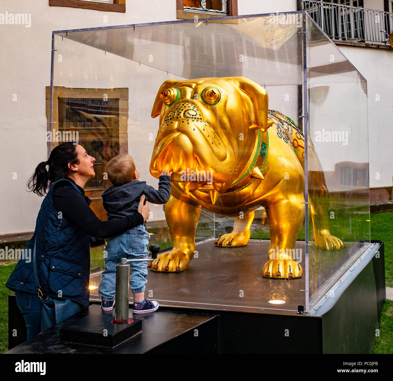 Femme et petit garçon à la recherche à Hector, British Bulldog sculpture dorée à la feuille d'or, sculpteur Renato Montanaro, affichage de rue, Strasbourg, Banque D'Images