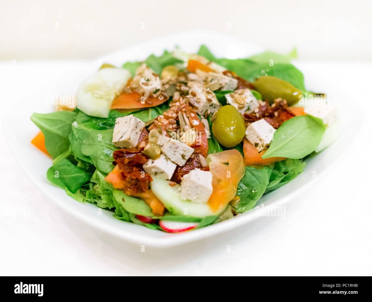 Salade d'été frais avec du thon cuit côtelettes, laitue, tomates, frresh radicchio vert et sec, tomates, concombres, olives vertes et diverses graines Banque D'Images