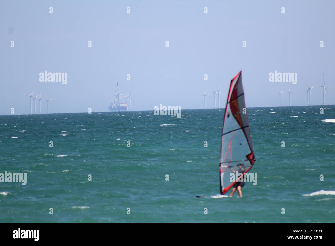 Wind surfer off Goring-par la mer et les éoliennes dans l'arrière-plan Banque D'Images