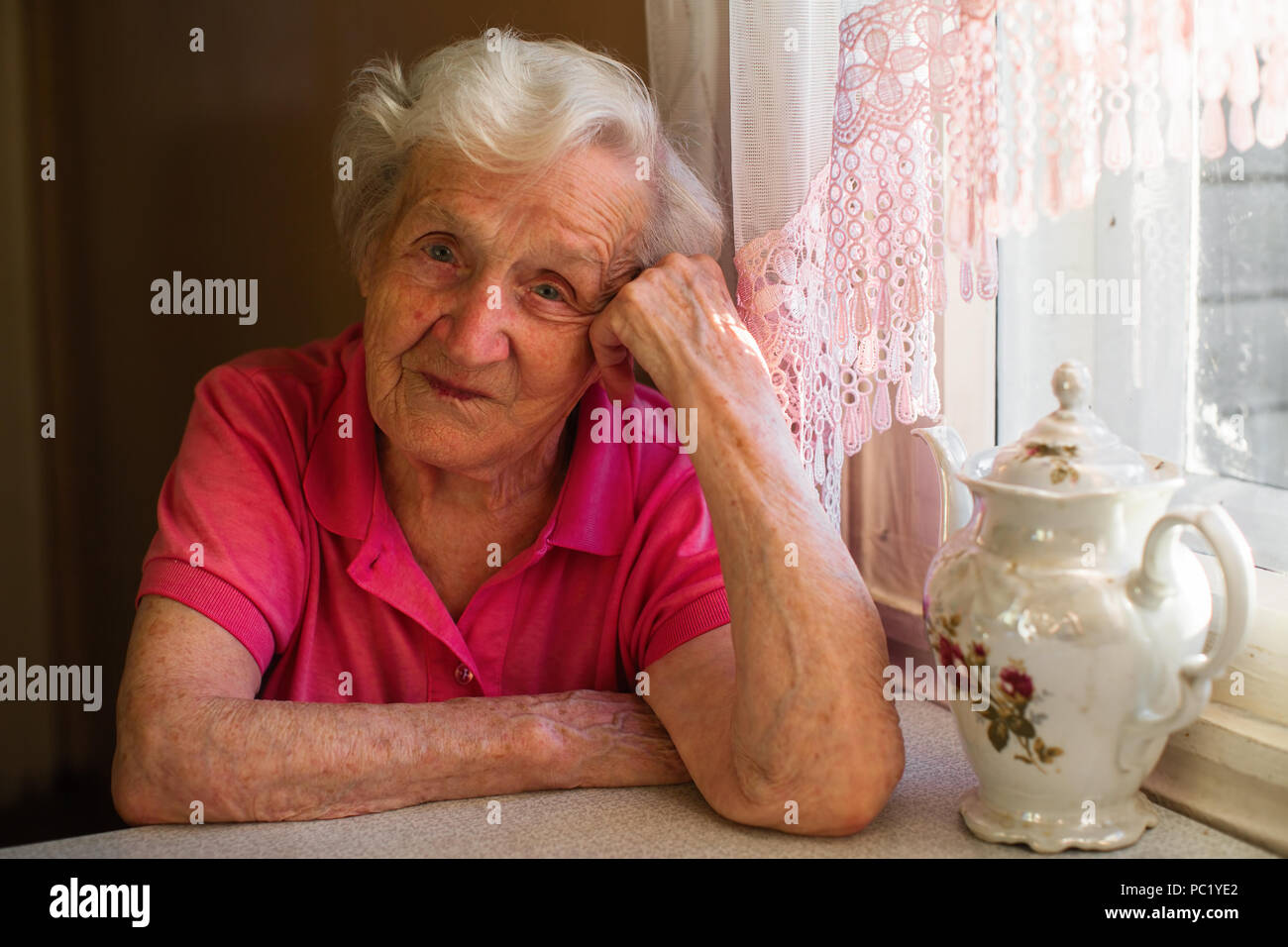 Portrait d'une femme âgée dans sa maison à la cuisine. Banque D'Images