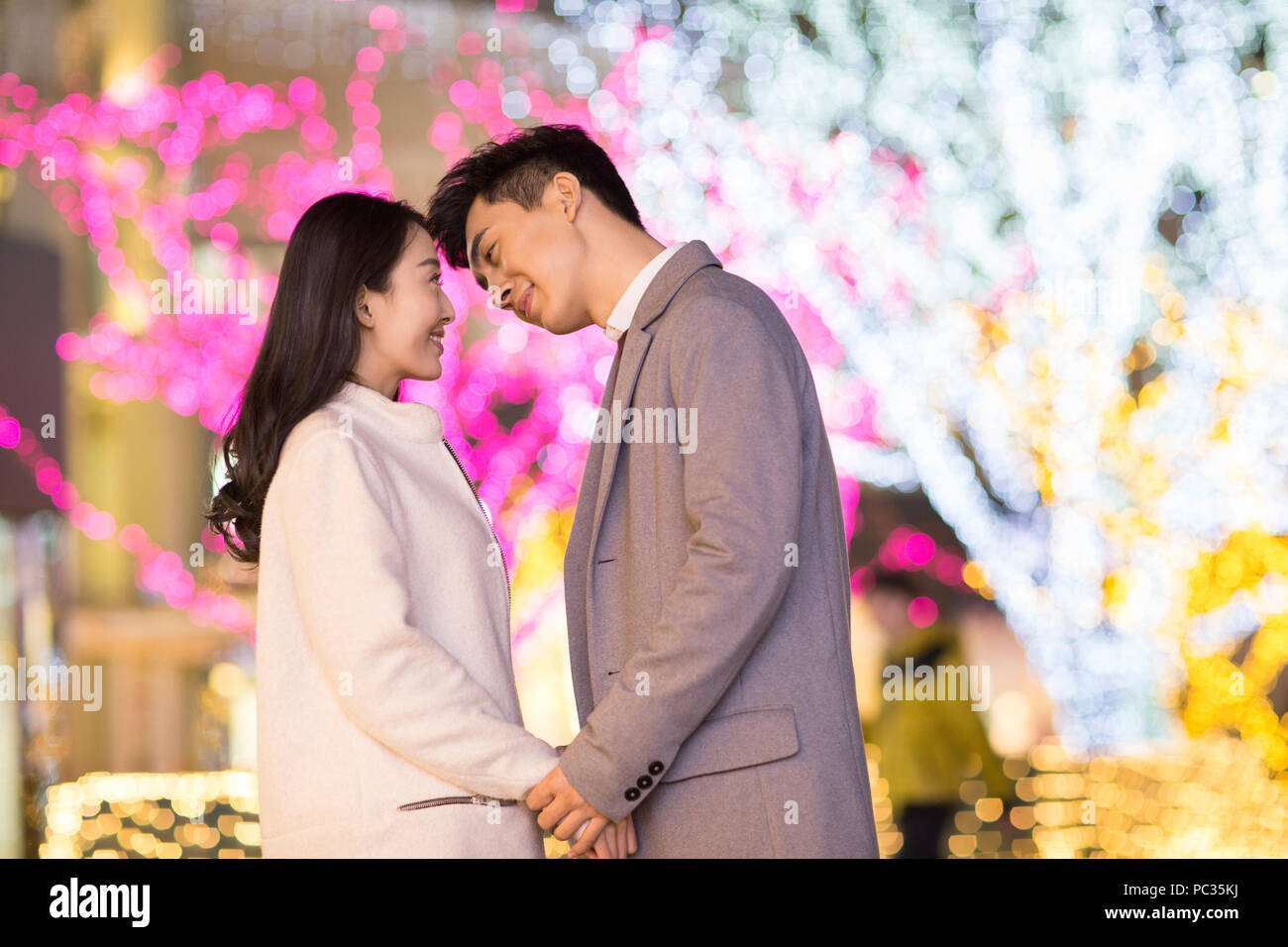 Cheerful young Chinese couple kissing Banque D'Images
