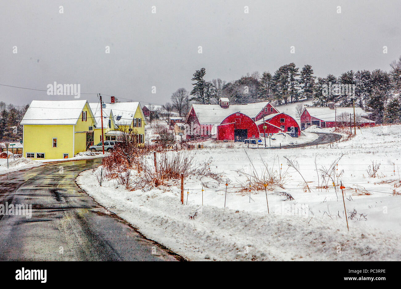 Ancienne ferme de la Nouvelle Angleterre sur une route de campagne sinueuse en hiver avec de la neige au sol à Lisbonne, NH, USA. Banque D'Images