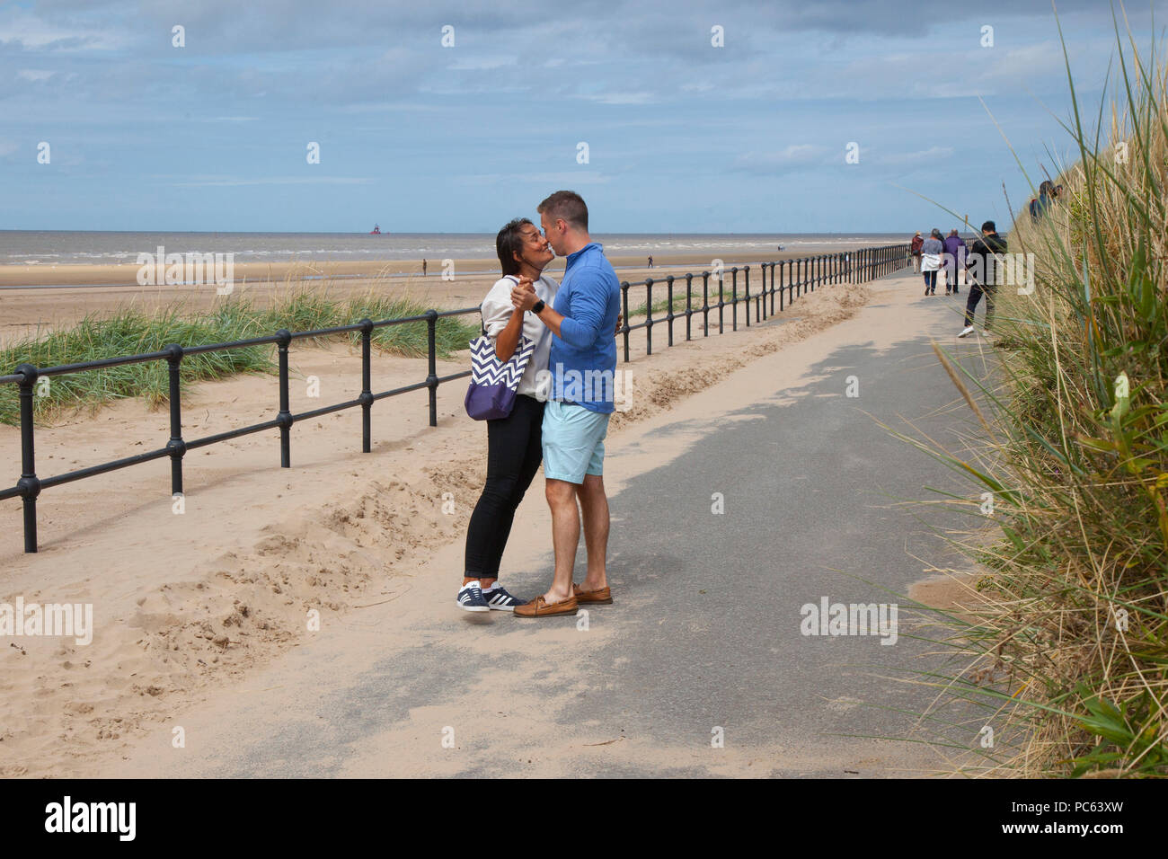 Crosby, Merseyside. Météo britannique. 31/07/2018. L'été revient au nord-ouest comme miel Debbie et James profitez d'un tour sur la promenade du front de mer. C'est le site connu sous le nom de "un autre endroit" avec les chiffres par Antony Gormley, répartis sur trois kilomètres de l'estran et les étirements près d'un kilomètre au large. /AlamyLiveNews MediaWorldImages:Crédit Banque D'Images