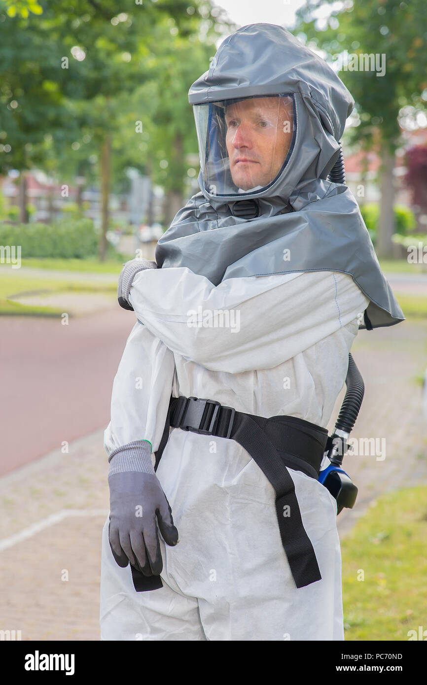Exterminateur d'insectes s'habille dans des vêtements de travail dans un secteur résidentiel Banque D'Images