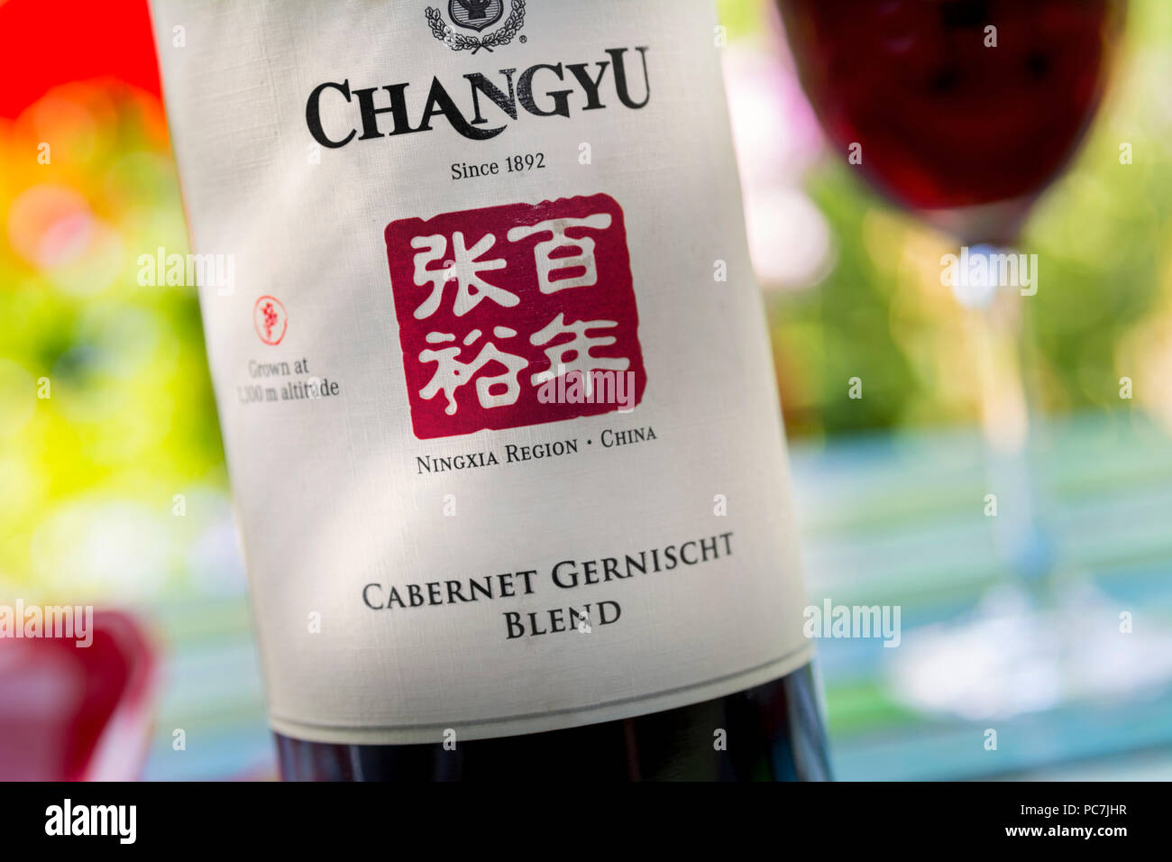 Fermer la vue sur la bouteille et l'étiquette de 'Chinois Changyu Cabernet Gernischt" vin rouge de la région de Ningxia Chine en situation de dégustation jardin en plein air Banque D'Images