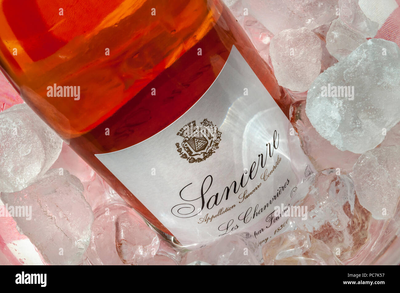 Sancerre Rosé bouteille 'Fournier' dans alfresco ice allumé par l'arbre de la lumière solaire sur nappe style typiquement français Banque D'Images