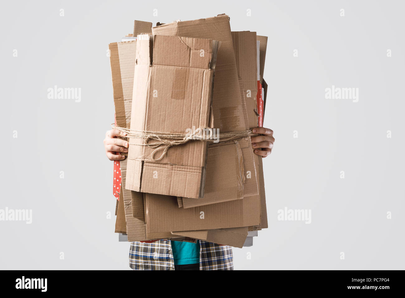 Cropped shot of man holding pile de boîtes en carton plié isolé sur gray, concept de recyclage Banque D'Images