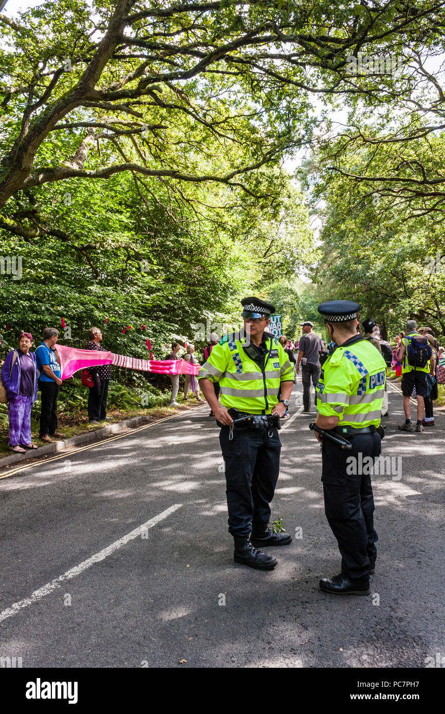 En service à la police d'une manifestation pacifique par des membres et sympathisants de la campagne pour le Désarmement Nucléaire (CND) près de l'AWE, Aldermaston. Banque D'Images