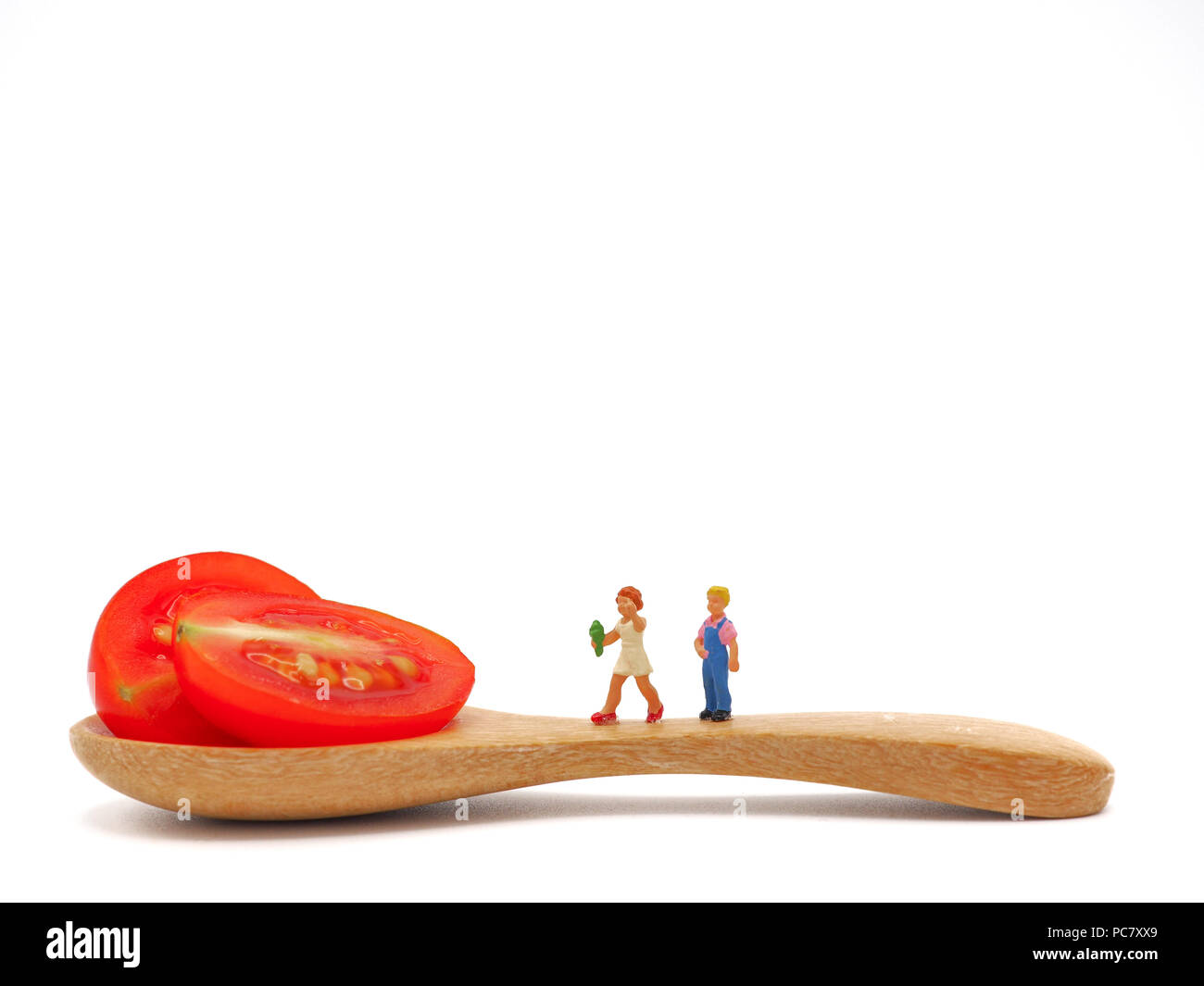 Enfants miniatures sur permanent ou de raisin frais tomate cerise avec une cuillère de bois, la pensée d'éléments nutritifs, sains et propres de la nourriture. Concept de vie sain Banque D'Images