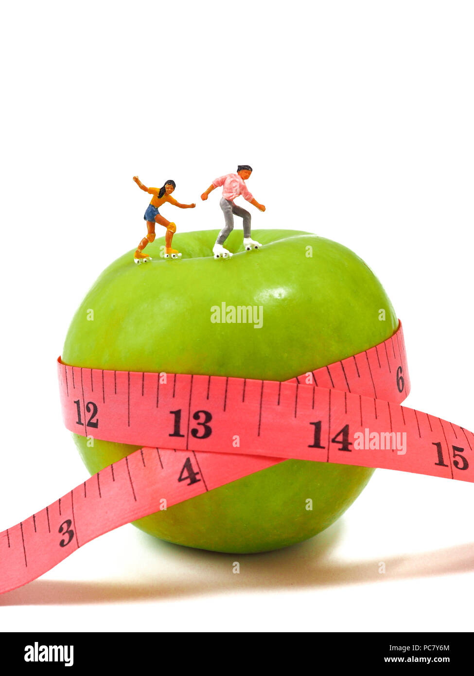 Femme miniature patinage sur la pomme verte et ruban à mesurer la pensée , de la perte de poids et de corps mince. Concept de vie sain. Banque D'Images