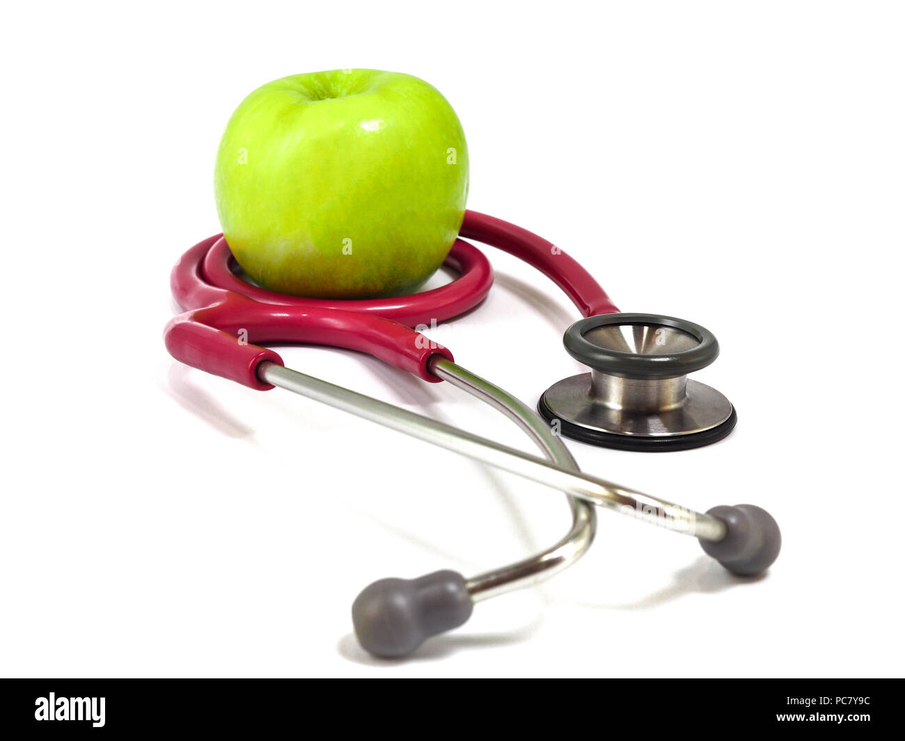 Stéthoscope et frais vert pomme sur fond blanc. Concept de vie et d'aliments sains. Banque D'Images