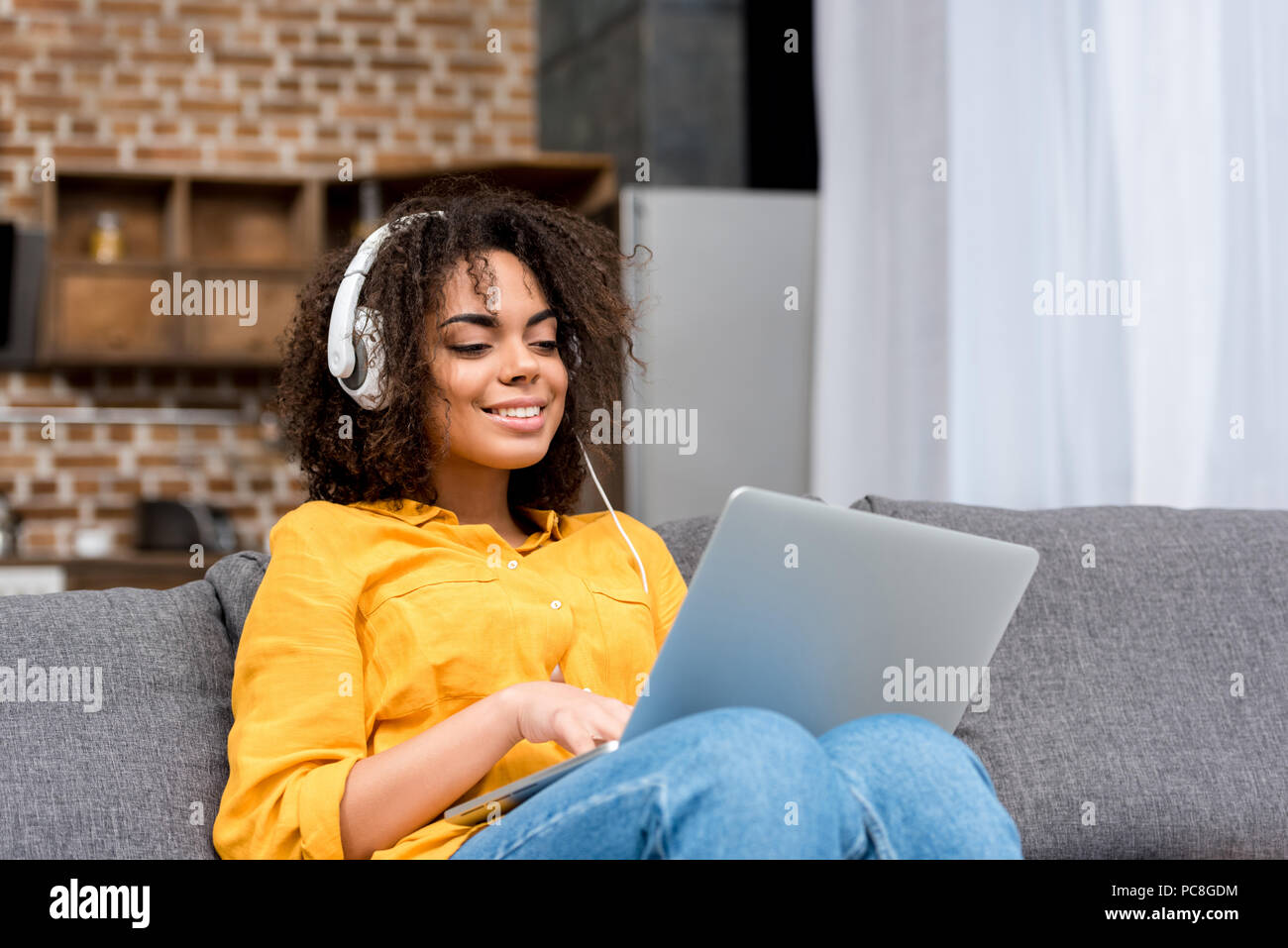 Happy young woman working with laptop et écouter la musique à la maison Banque D'Images