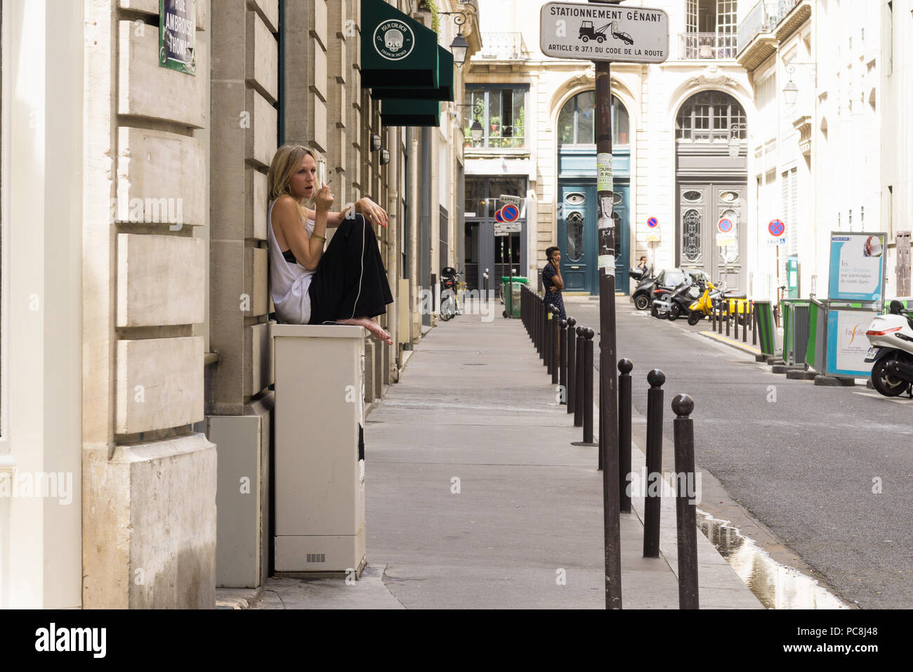 Femme Paris - Scène de rue parisienne détendue pieds nus femme parlant au téléphone dans la rue, en France, en Europe. Banque D'Images