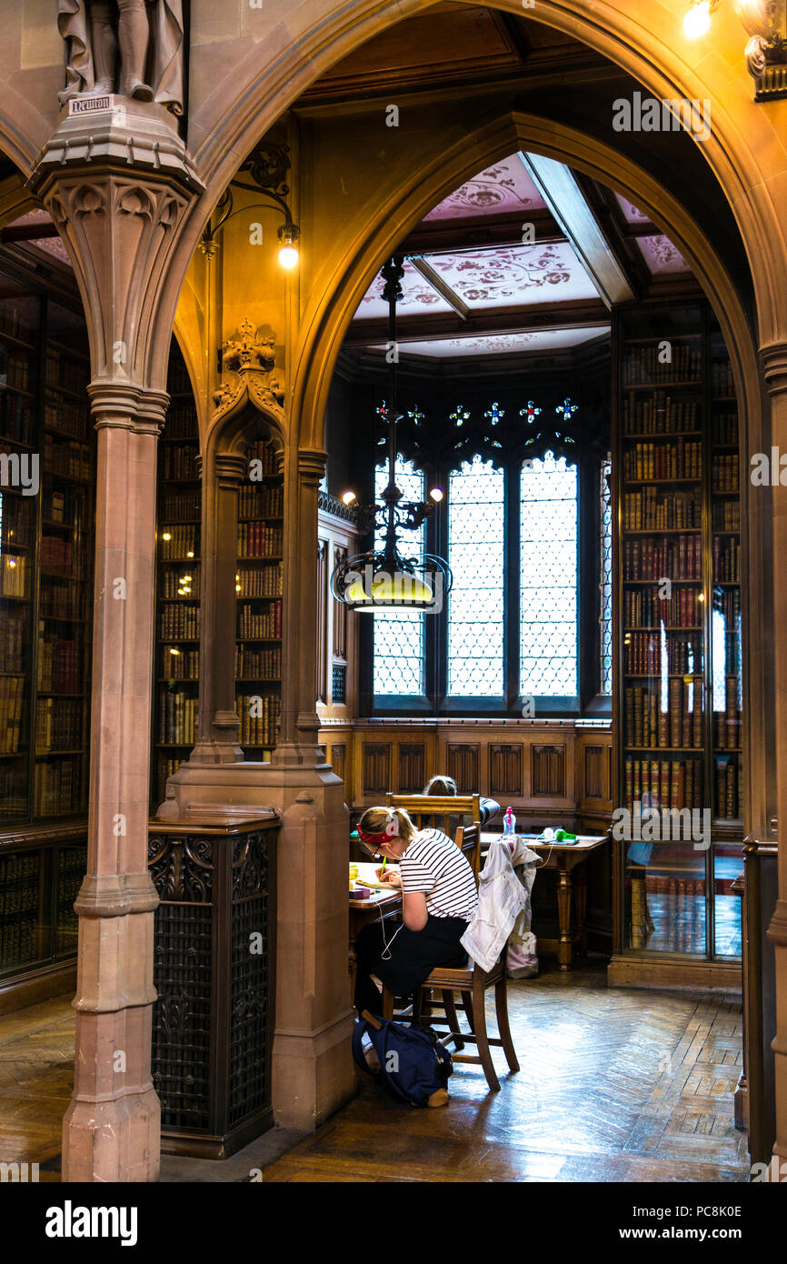 Femme étudie, la recherche à une vieille bibliothèque salle de lecture, la bibliothèque John Rylands, Manchester, UK Banque D'Images