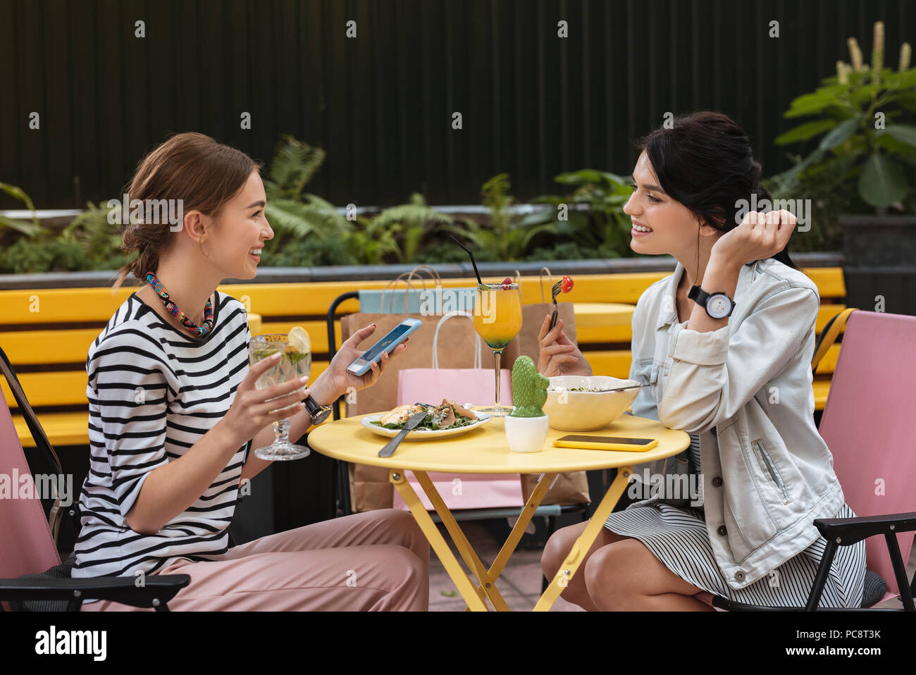 Réunion informelle. Deux stylistes prometteurs tout en ayant joyeuse sensation réunion informelle de cafe Banque D'Images