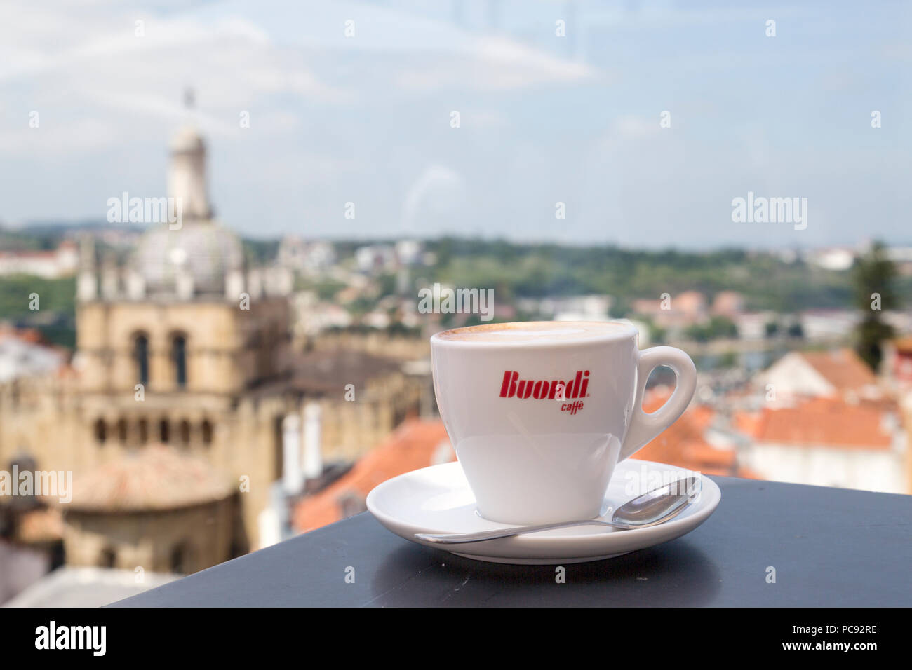 Tasse à café et soucoupe sur la table de café, avec vue sur la ville de Coimbra à partir d'un patio extérieur. Banque D'Images