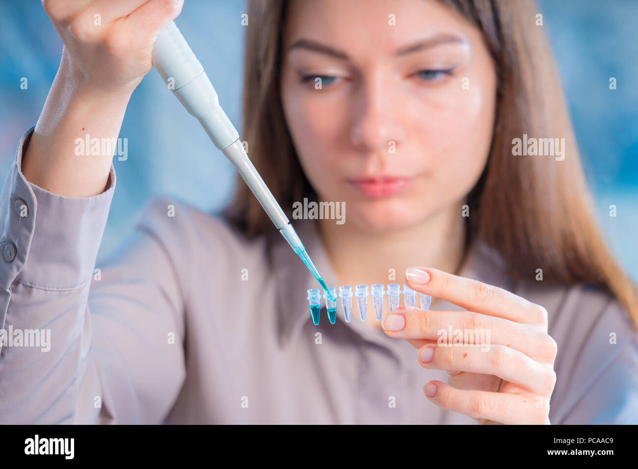 Technicien de sexe féminin à la pipette dans cont pour des tests médico-légaux ADN Banque D'Images