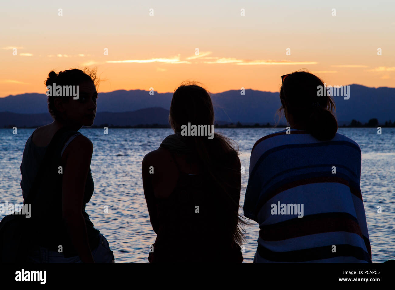 Les gens sur le dos regardant le coucher du soleil sur la plage Photo Stock  - Alamy