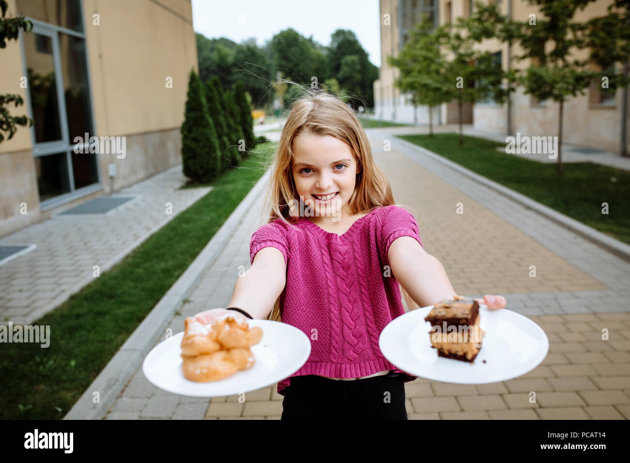 Une jeune fille tenant une assiette de gâteaux. Little cutie. Banque D'Images