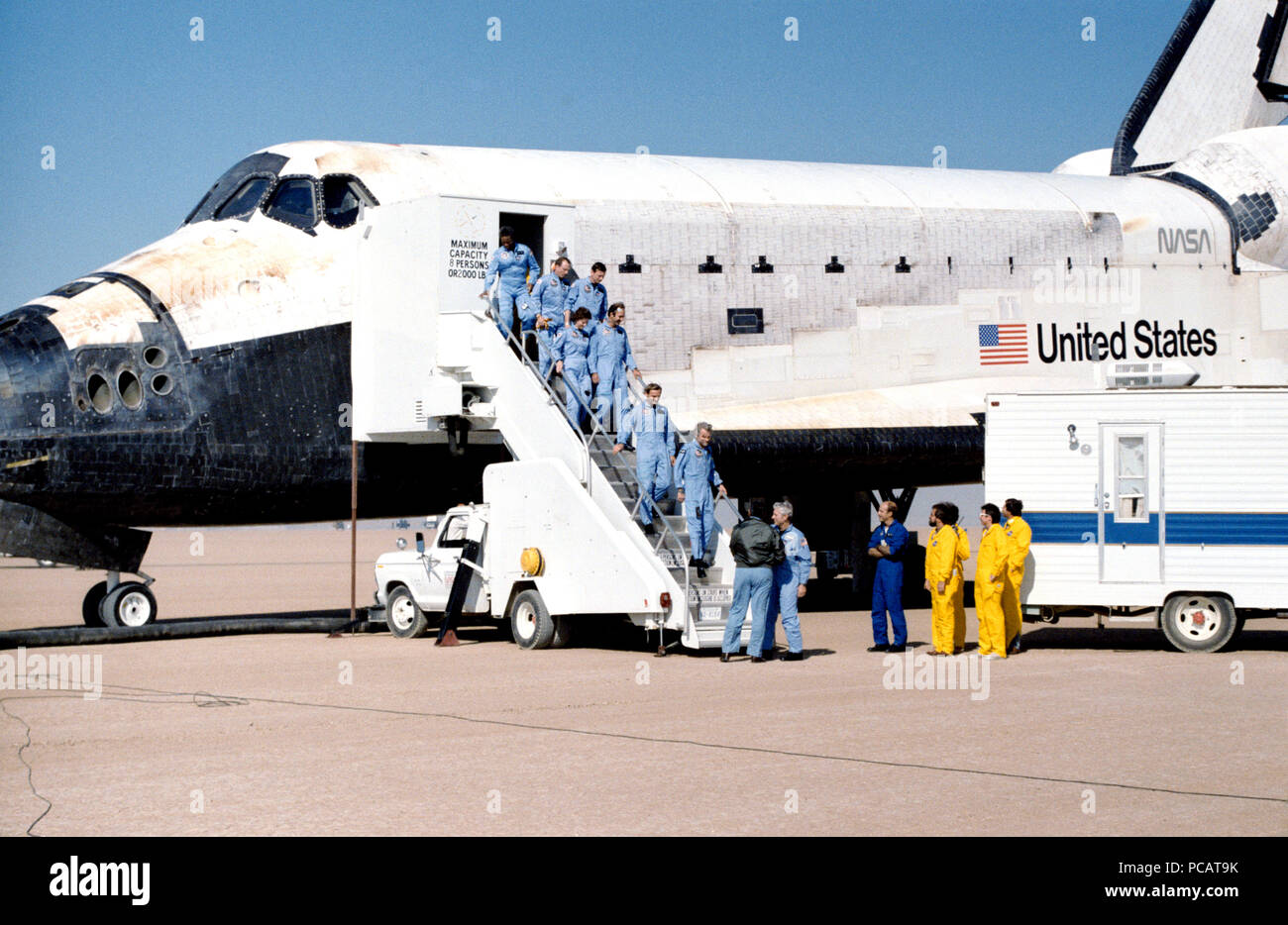 L'équipage de la mission STS 61-A la sortie de l'orbiteur après l'atterrissage. Henry W. astronaute Jr., Hartsfield 61-Un commandant de mission, serre la main de George W. Abbaye, Directeur des opérations à l'équipage de JSC, comme le reste de l'équipage descend les marches. De gauche à droite sont Guion S. Bluford, Jr, James F. Buchli, Steven R. Nagel, Bonnie J. Dunbar, J. Wubbo Ockels, Ernst Messerschmid, et Reinhard Furrer. Le 6 novembre 1985 Banque D'Images