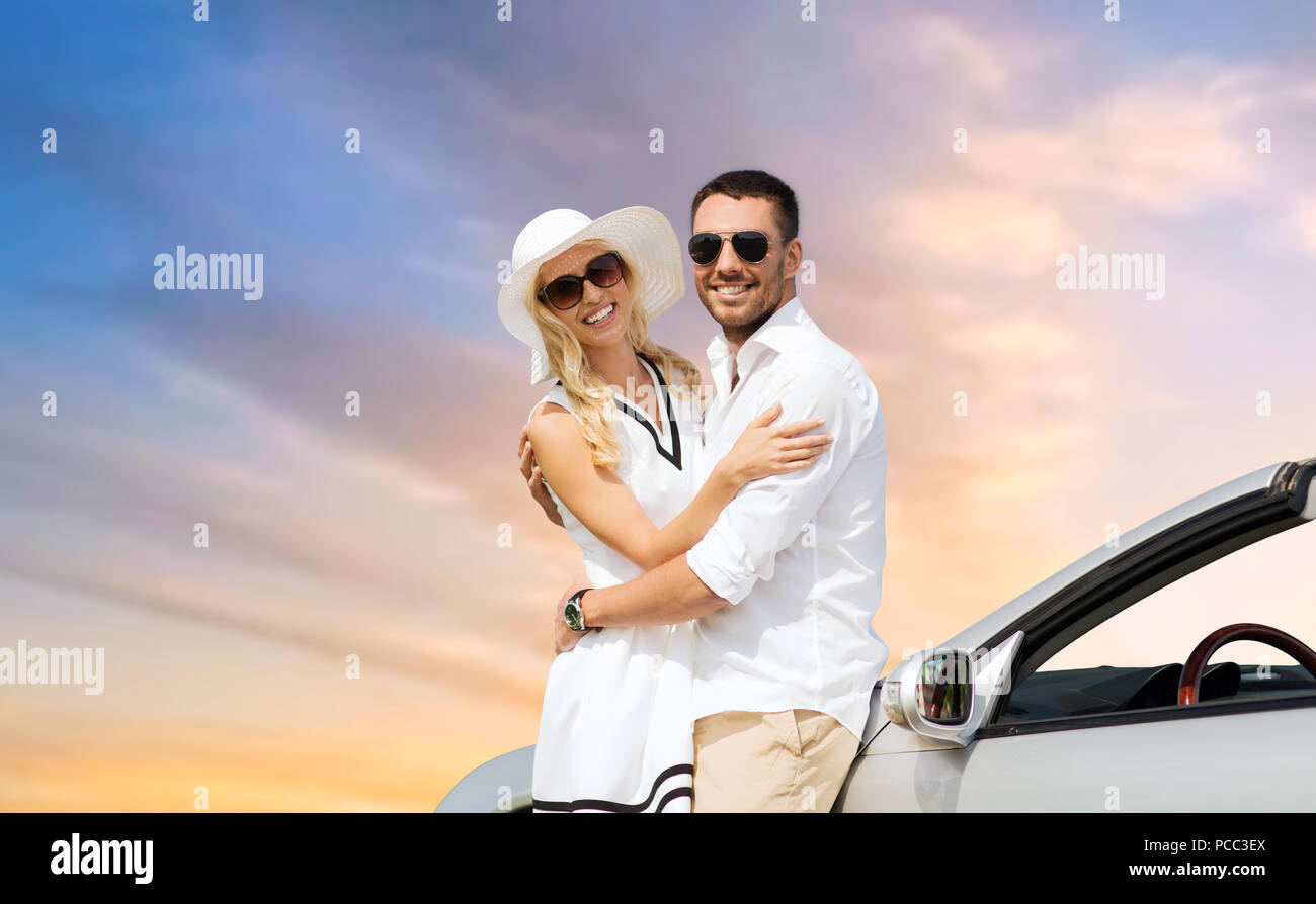 Heureux couple hugging près de voiture décapotable sur sky Banque D'Images