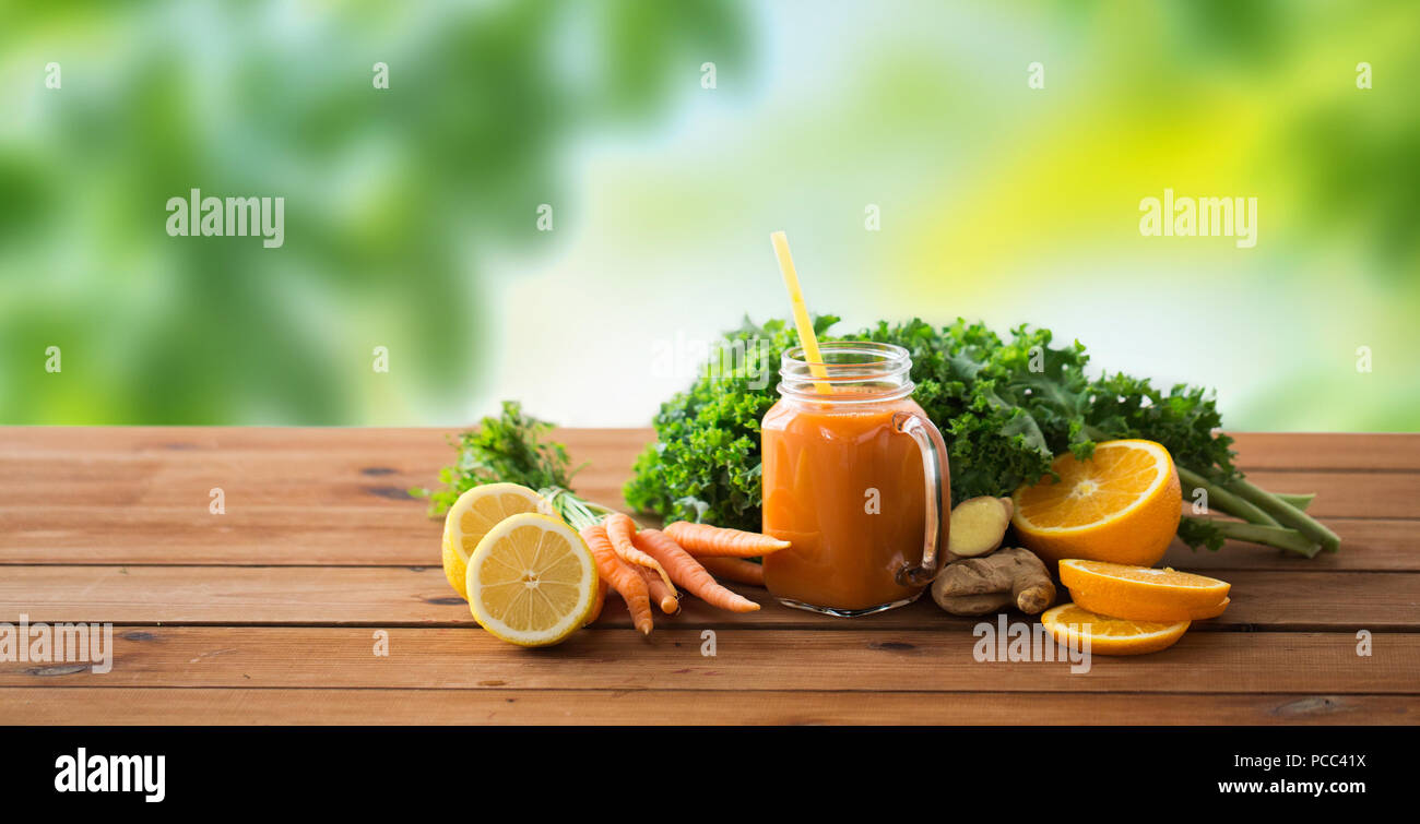 Verseuse en verre de jus de carotte, fruits et légumes Banque D'Images