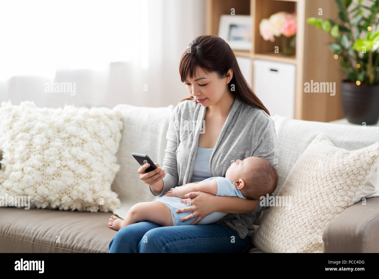 Maman Avec Bebe Endormi Et Smartphone A La Maison Photo Stock Alamy Maman Avec Bebe Endormi Et Smartphone A La Maison Photo Stock Alamy