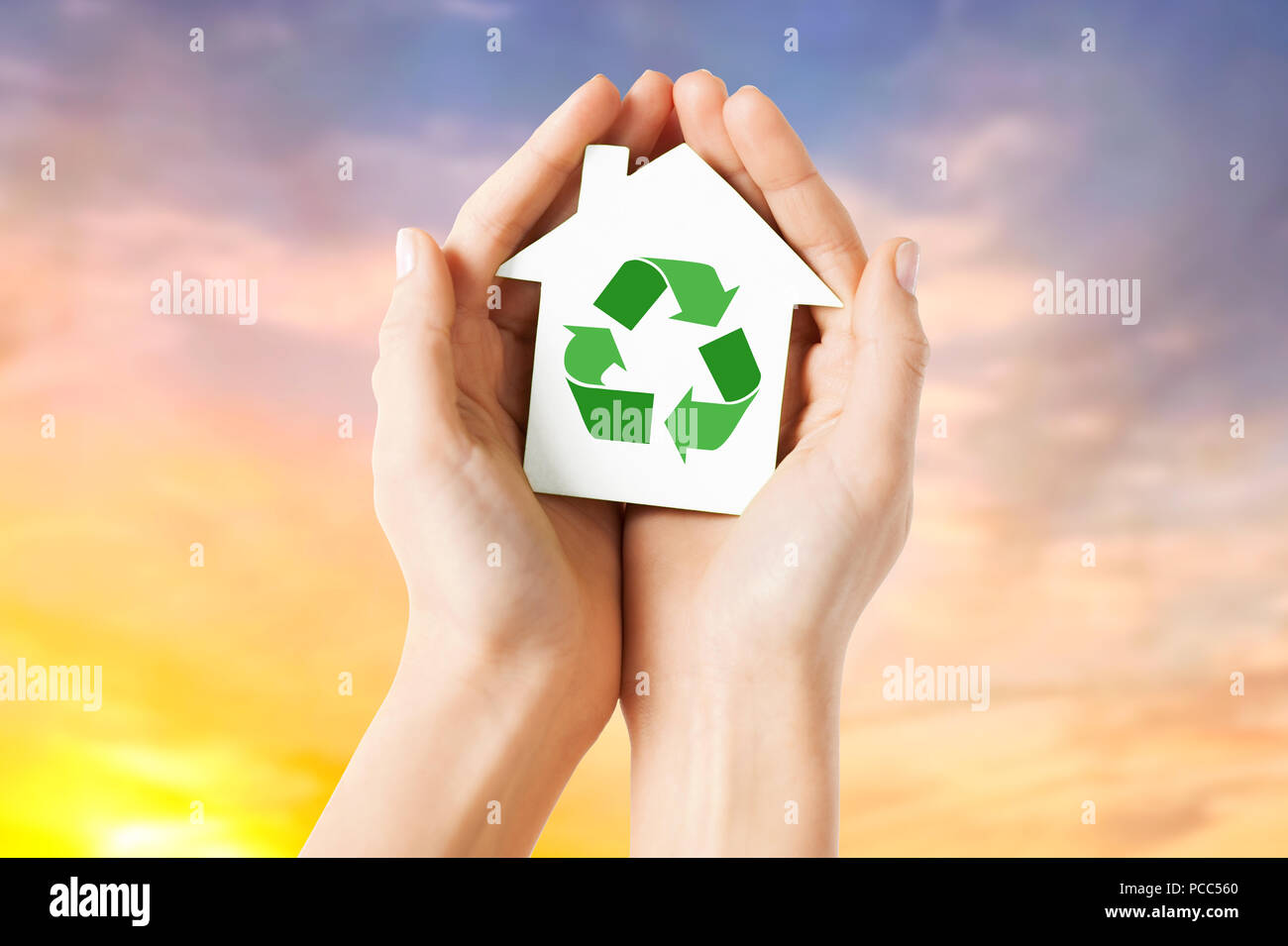 Mains tenant maison avec green recycling sign Banque D'Images