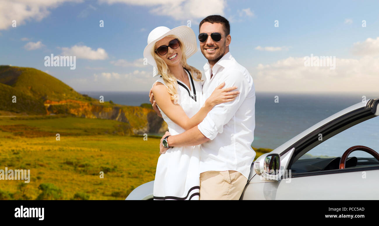 Heureux couple hugging près de voiture décapotable Banque D'Images