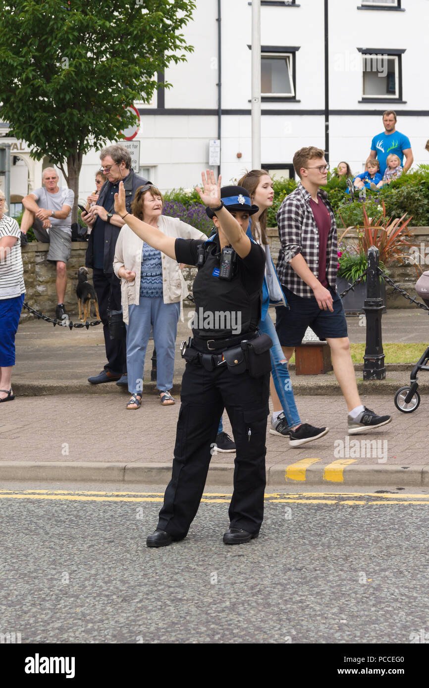 Femme officier de police et de sécurité communautaire ou PCSO en service Direction de la circulation à Llangollen Nord du pays de Galles pendant la rue Eisteddfod parade Banque D'Images