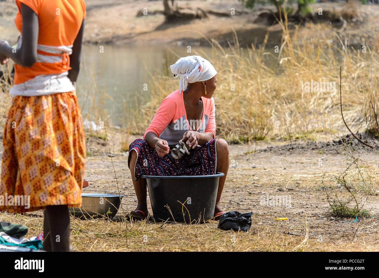 TECHIMAN, GHANA - Jan 15, 2017 : Sandales femme ghanéenne non identifiés dans un noir nettoie le bassin sur la lave-jour, ce qui est tous les dimanches Banque D'Images