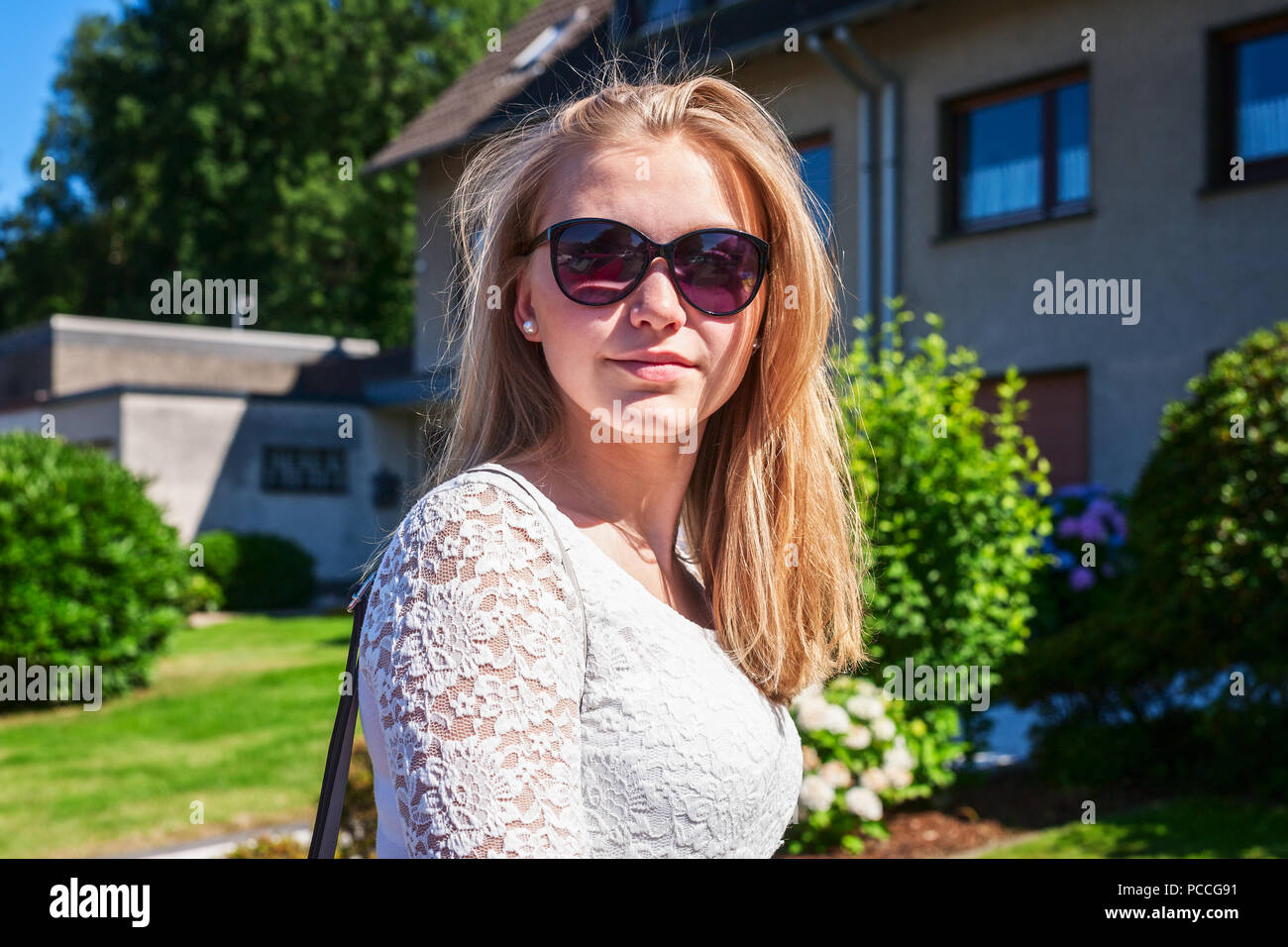 De vie de plein air portrait de jeune adolescente avec de longs cheveux blonds et des lunettes à l'extérieur chambre dans summer city Banque D'Images