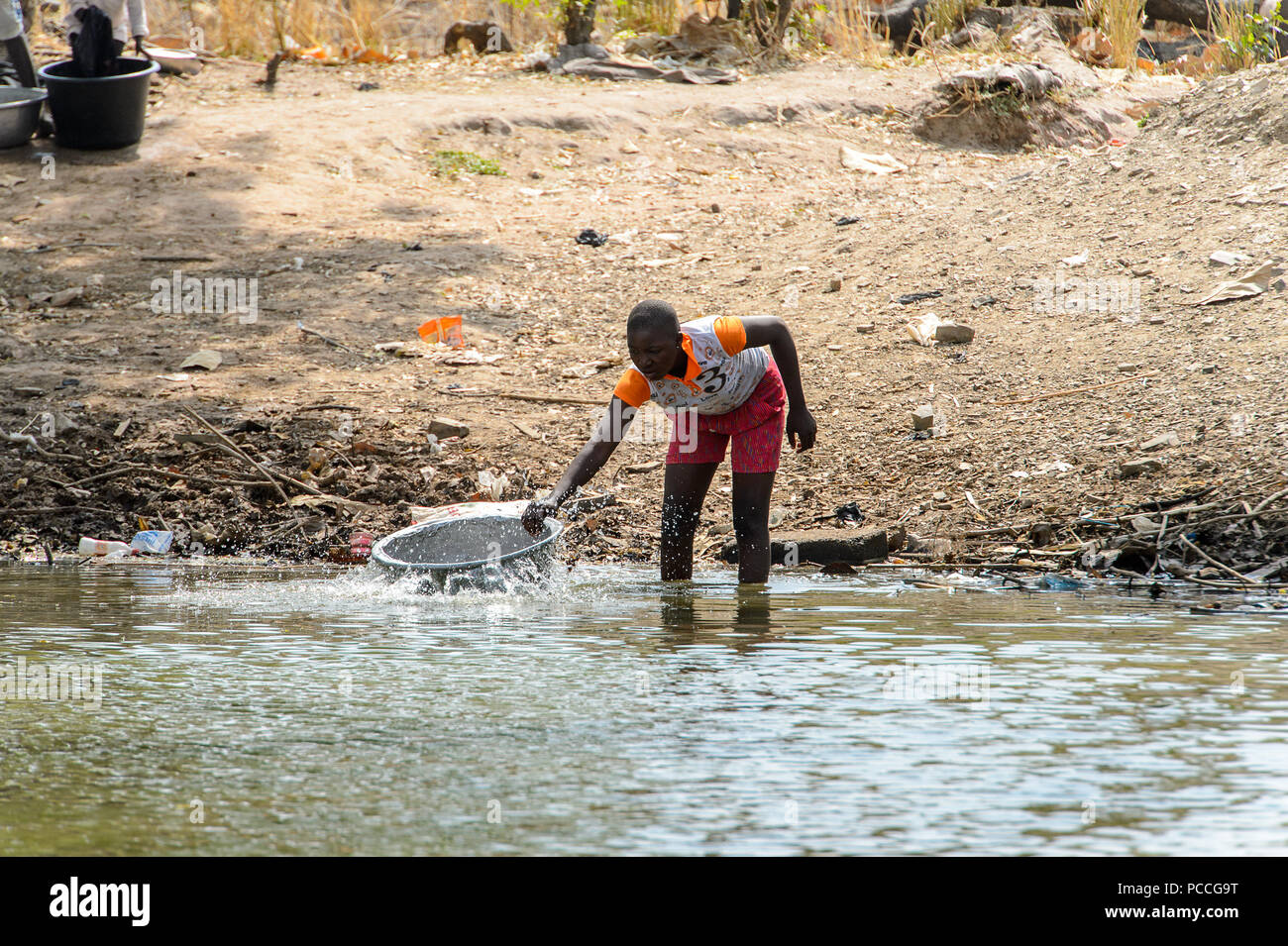 TECHIMAN, GHANA - Jan 15, 2017 : Ghana non identifiés fille obtient de l'eau lac avec un basib sur le lave-jour, ce qui est tous les dimanches Banque D'Images