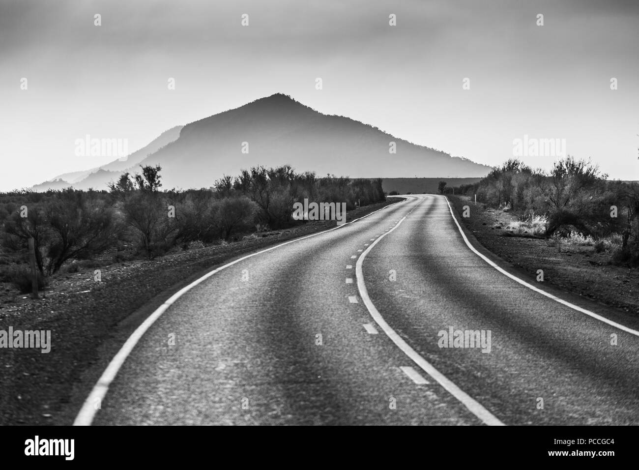 Campagne de flexion route conduisant à une belle pic de montagne en noir et blanc Banque D'Images