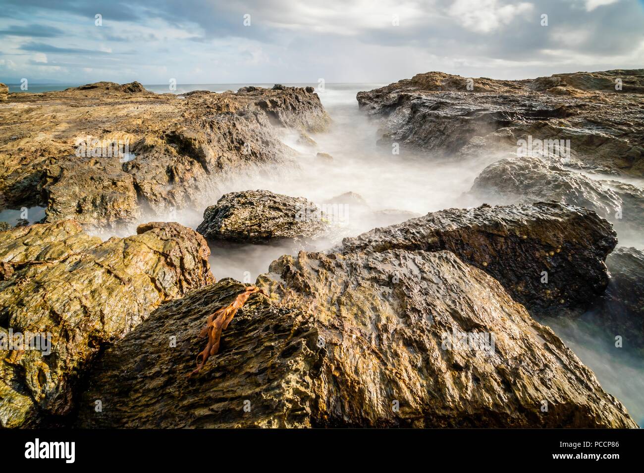 Les roches de la mer dans la lumière du matin avec un ciel voilé, long exposure mer Banque D'Images