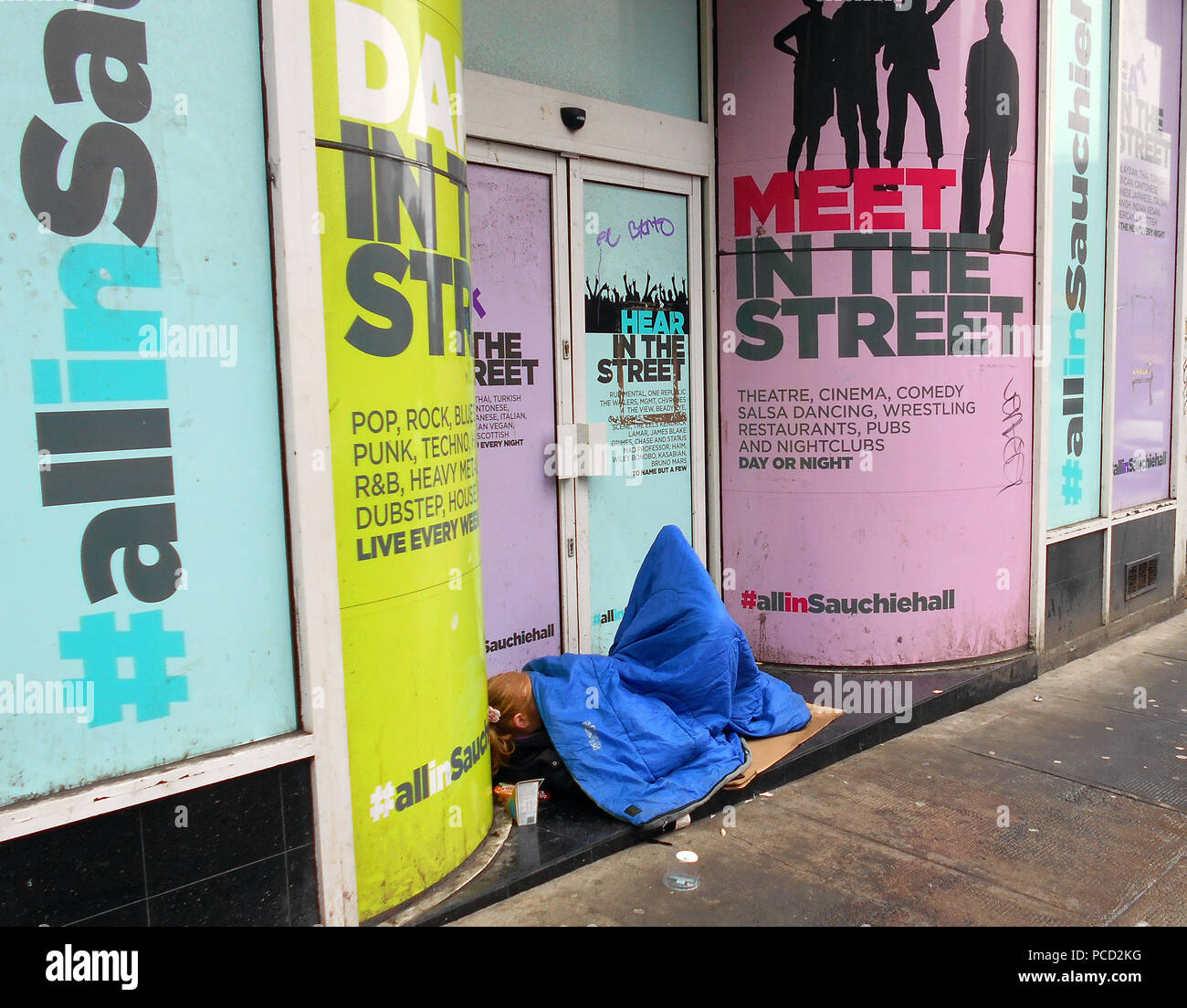 Une personne sans-abri est à la rue à la porte d'un atelier fermé à Glasgow. Banque D'Images