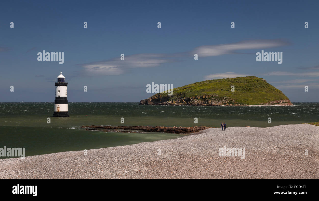 Phare de Penmon Point, Anglesey, au nord du Pays de Galles avec l'île de macareux dans l'arrière-plan Banque D'Images