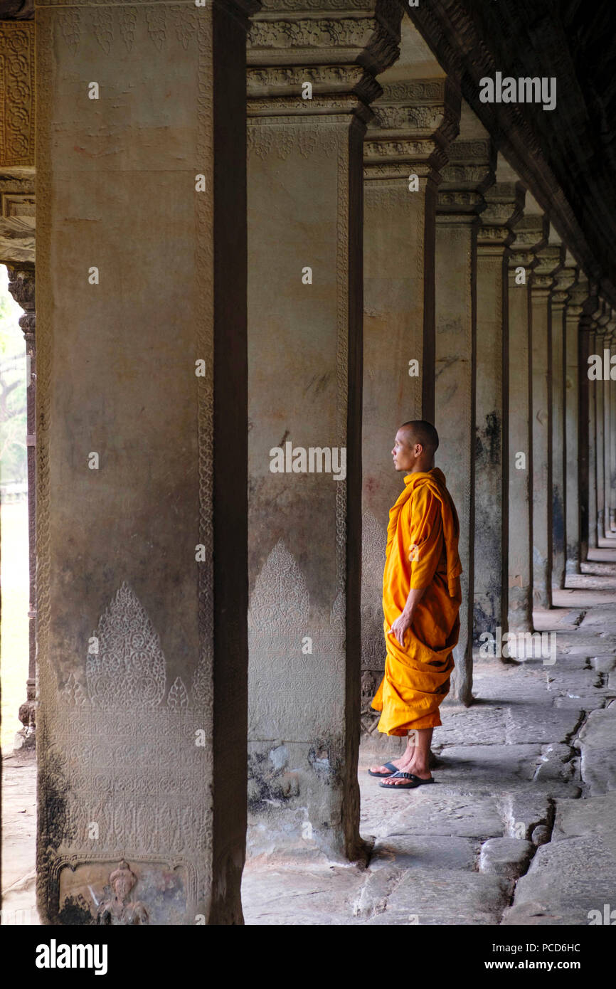 Le moine bouddhiste dans un corridor à colonnade dans un temple à Angkor Wat, Site du patrimoine mondial de l'UNESCO, Siem Reap, Cambodge, Indochine, Asie du Sud, Asie Banque D'Images