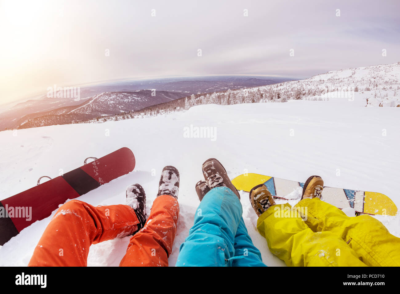 Les planchistes les jambes et snowboards contre coucher du soleil Banque D'Images