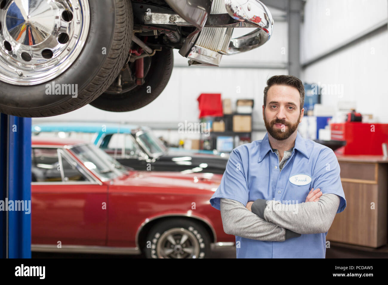 Un portrait d'un mécanicien de race blanche dans son atelier de réparation de voitures classiques. Banque D'Images