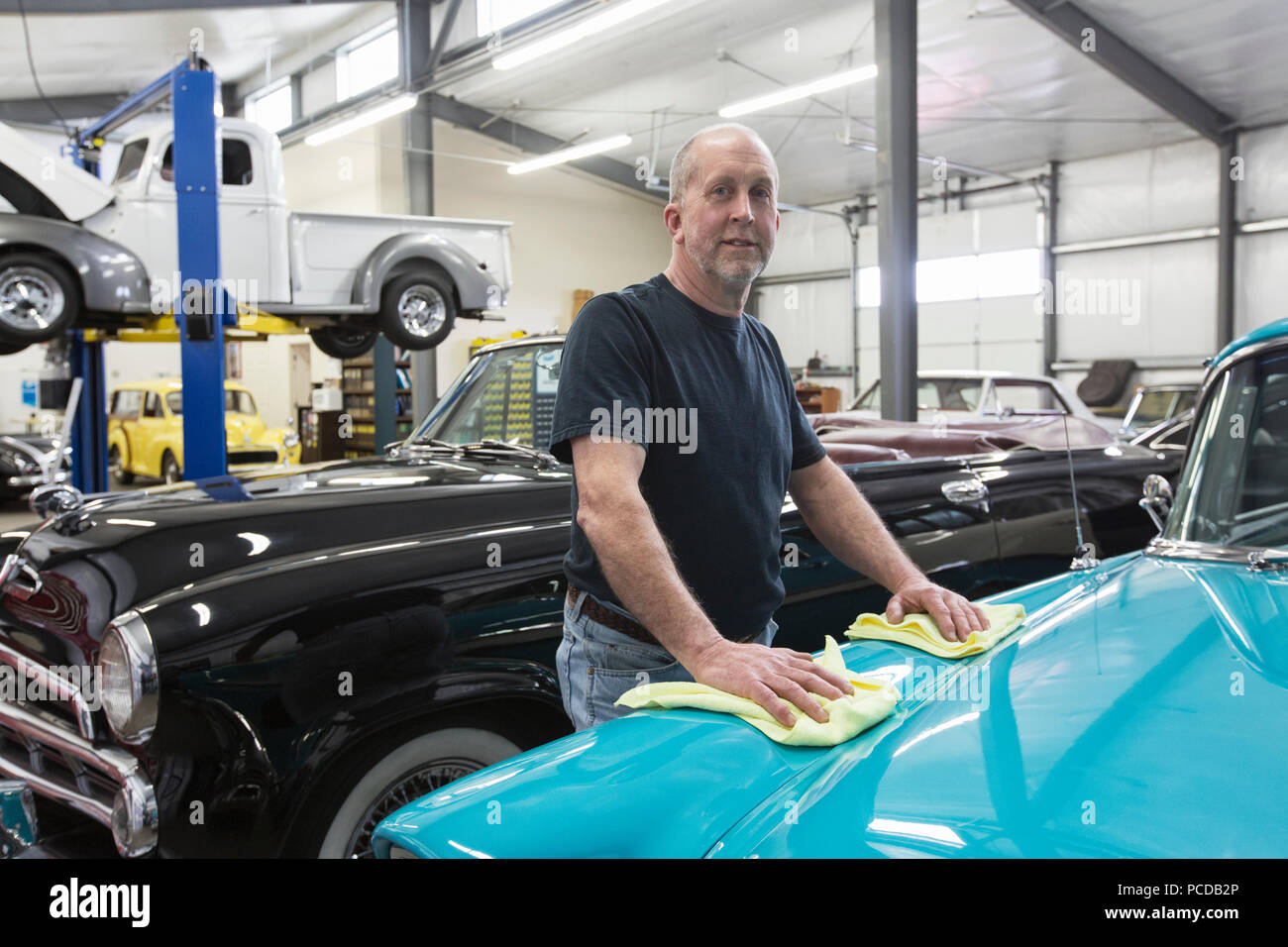 Un homme de race blanche dans mechnic senior voiture ihs voiture classique atelier de réparation. Banque D'Images
