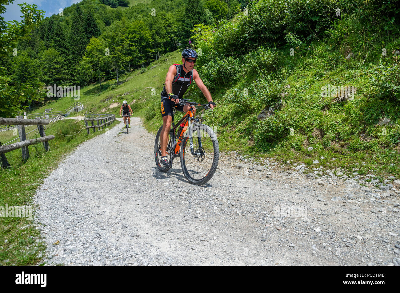 Cycliste en vtt descente d'une montagne sur une piste de gravier. Banque D'Images